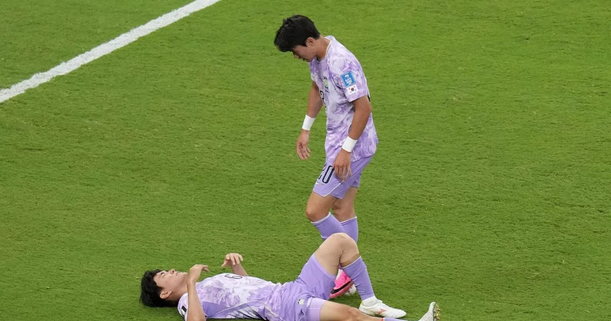 Yang Hyun-jun stands over a teammate lying on the pitch